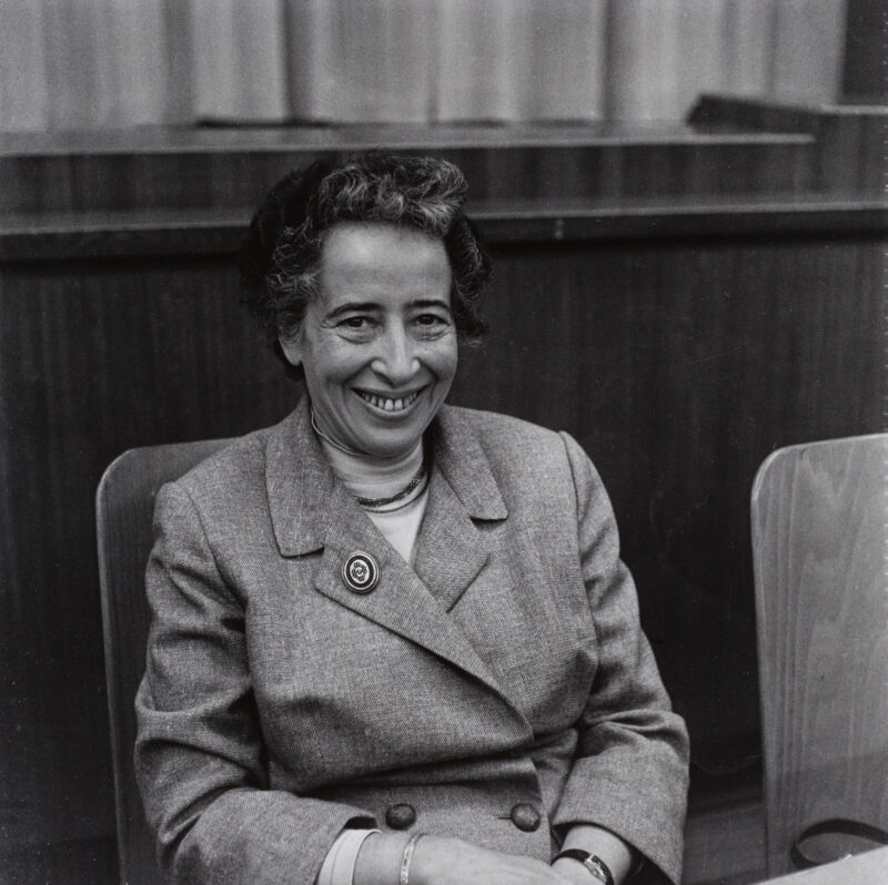 Hannah Arendt An older woman is seen sitting in a black and white photo.