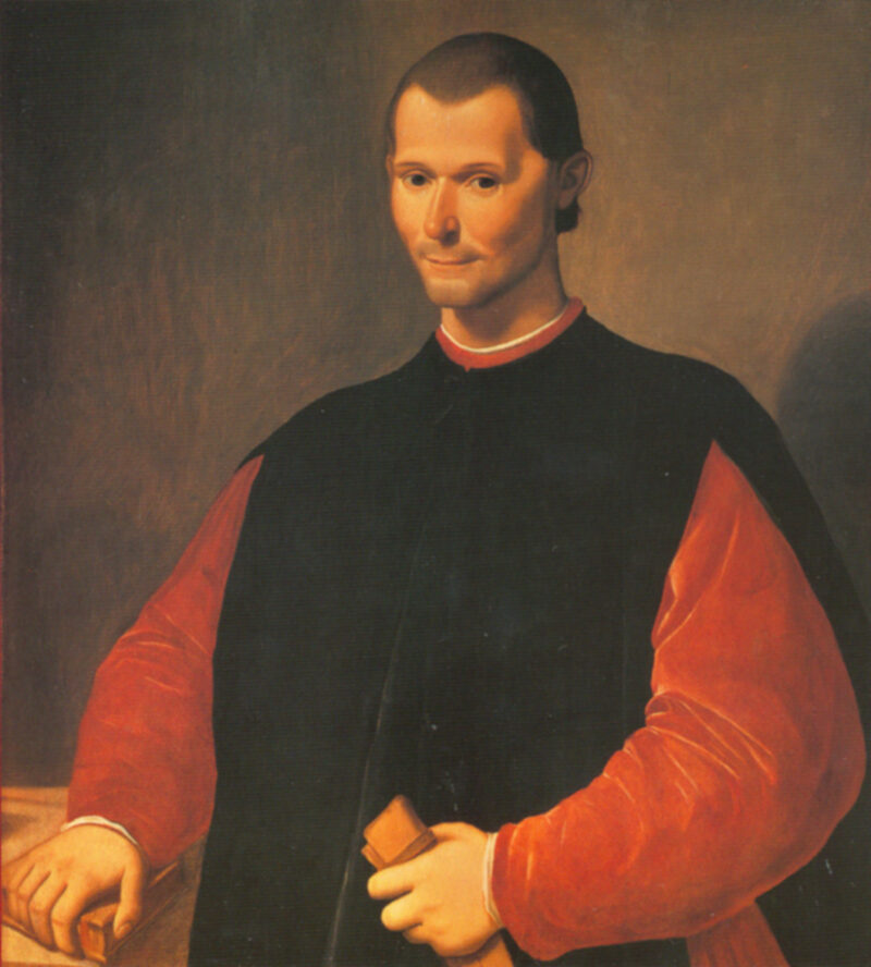 Niccolo-Machiavelli A painted portrait is shown of a man from the waist up. He has a small head and is wearing a red shirt with a black robe over it.