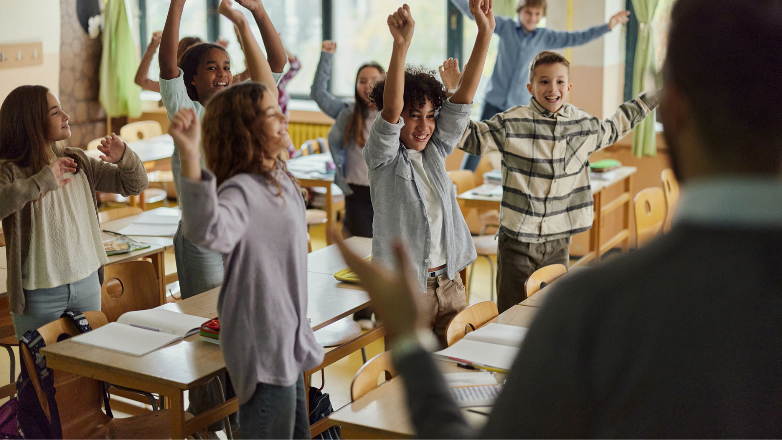 Photo of students and teacher celebrating about four day school weeks