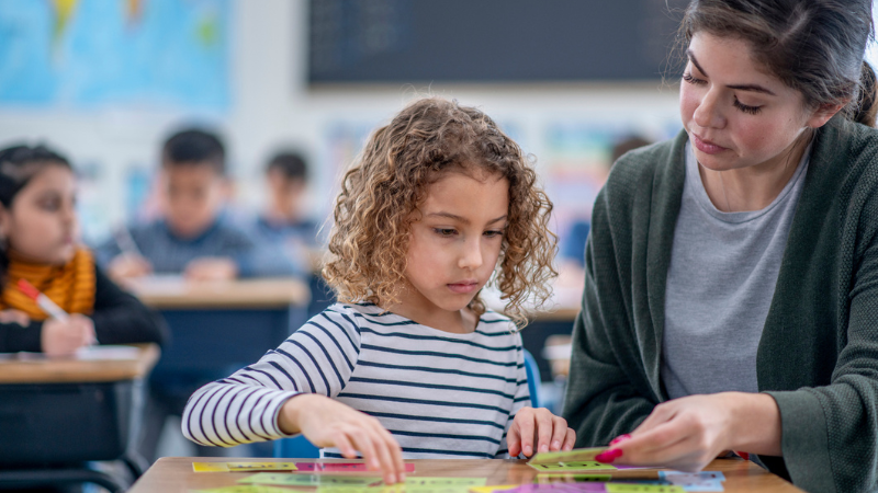 Teacher helping student learning to read